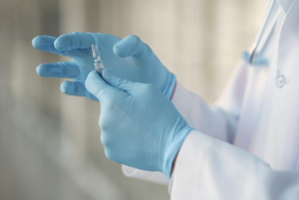 pexels photo 3985171 3985171 Close-up of a healthcare professional in gloves holding a glass vaccine ampoule.